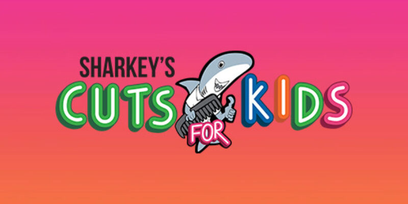 A pink and orange gradient square with Sharkey's Cuts for Kids. There is also an image of a cartoon shark holding a comb.