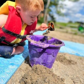 Luke plays in sand at the beach