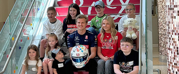 Marcus Ericsson holds 2024 Riley Helmet with Artists