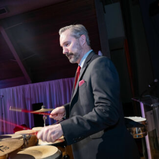 Man drumming at Riley Red event