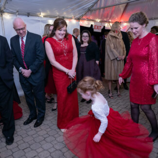 Red For Our Kids event. Little girl twirling her dress.