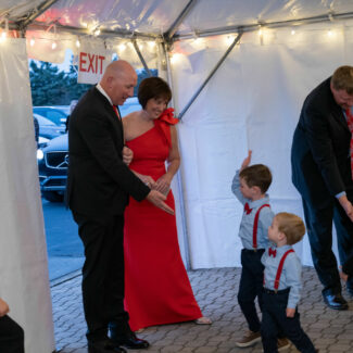 Riley kids high-fiving couple as the enter a tent at Riley Red event