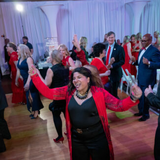 Woman dancing on the ballroom at the Riley Red event.